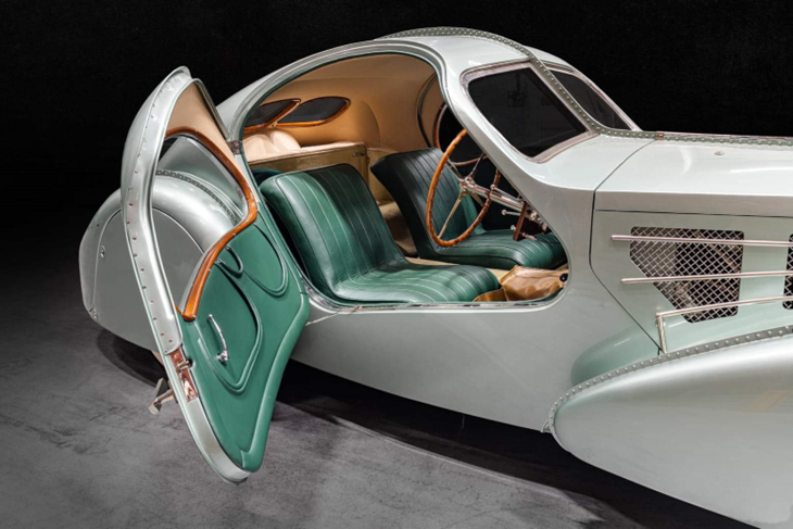 Doors that sweep into the roof; green-leather cabin.